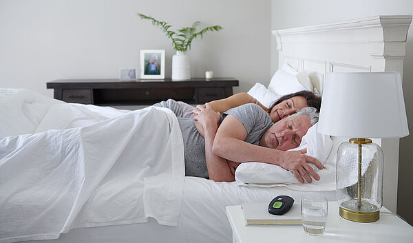 Schlafendes Ehepaar im Bett, neben ihnen die Inspire Fernbedienung