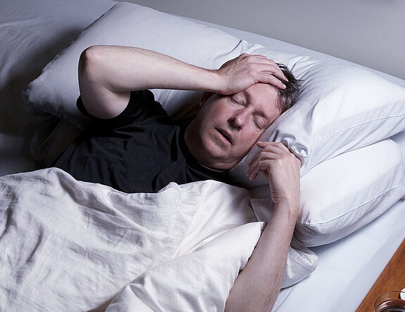 Schlafloser Mann im Bett. Schlafstörungen schaden der Gesundheit.  