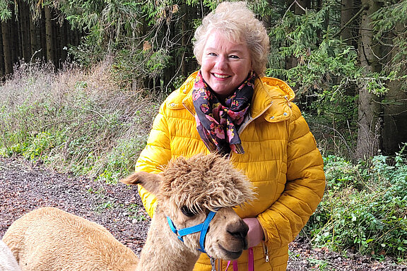 Inspire Nutzerin Petra B. im Wald mit einem Alpaka