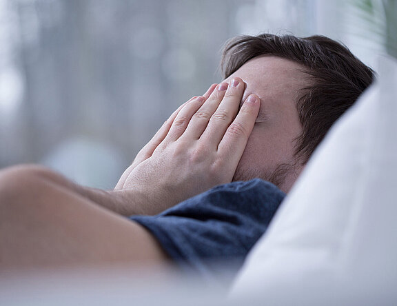 Schlafloser Mann im Bett. Schlafstörungen schaden der Gesundheit.  