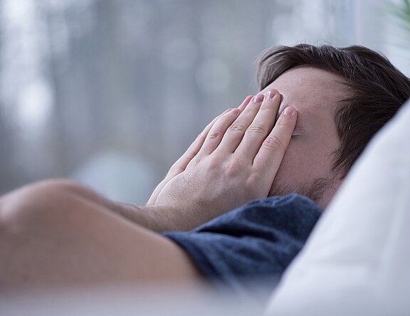 Schlafloser Mann im Bett. Schlafstörungen schaden der Gesundheit.  