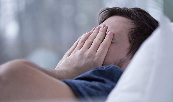 Schlafloser Mann im Bett. Schlafstörungen schaden der Gesundheit.