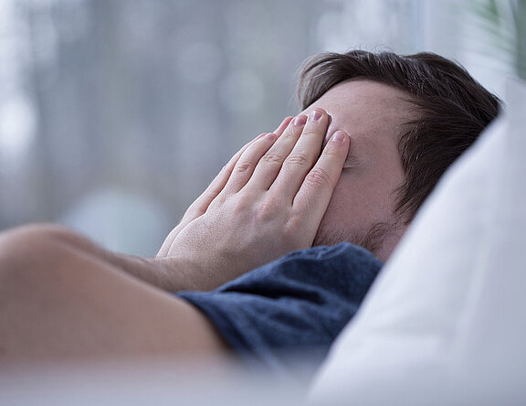 Schlafloser Mann im Bett. Schlafstörungen schaden der Gesundheit.  