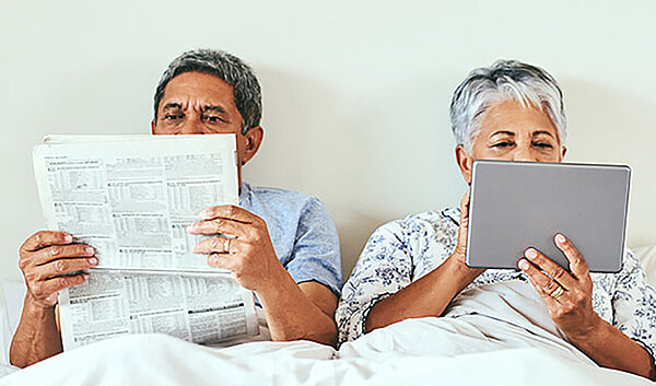 Paar liest Schlafapnoe News im Bett