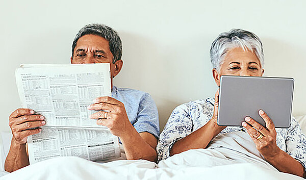 Paar liegt im Bett und liest Informationen über die Inspire Therapie
