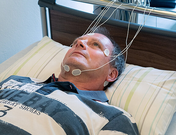 Im Schlaflabor: Mann hat Elektroden für EEG am Kopf