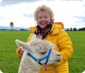 Inspire Nutzerin Petra B. mit einem Alpaka auf einer Wiese